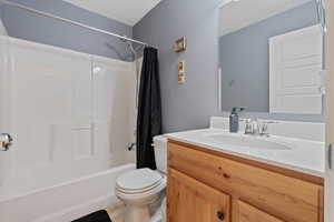 Bathroom featuring shower / bathtub combination with curtain, vanity, and a textured ceiling