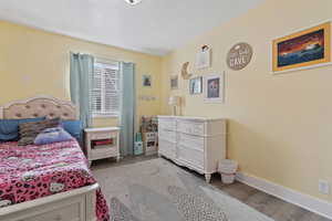 Bedroom with light wood finished floors and a textured ceiling