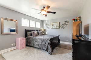 Bedroom featuring a textured ceiling, light wood finished floors, and ceiling fan