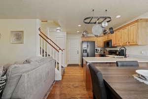 Kitchen featuring recessed lighting, light countertops, black / electric stove, dark wood-type flooring, and open floor plan