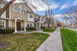 View of front facade featuring a residential view, a front lawn, and stone siding