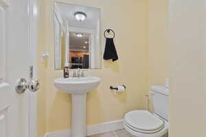 Bathroom featuring light tile patterned floors and toilet