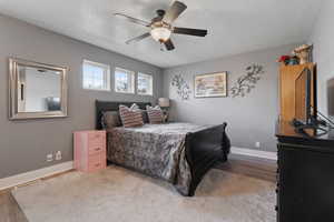 Bedroom featuring a textured ceiling, a ceiling fan, and wood finished floors