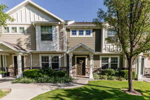 Multi unit property featuring board and batten siding, stone siding, and a front yard