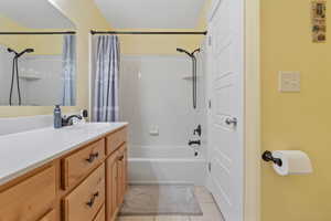 Bathroom with shower / tub combo, vanity, and light tile patterned floors