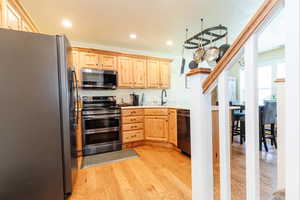 Kitchen featuring appliances with stainless steel finishes, light brown cabinetry, light wood-style floors, light countertops, and recessed lighting