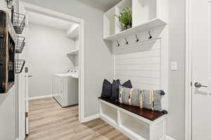 Mudroom with light wood-style floors and washing machine and dryer