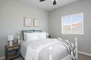 Carpeted bedroom with baseboards and a ceiling fan
