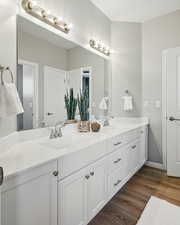 Bathroom with double vanity and wood finished floors