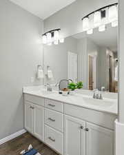 Full bath with double vanity and wood finished floors