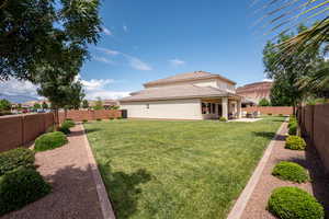 Rear view of house with a fenced backyard and a patio