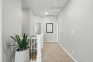 Hall featuring an upstairs landing and carpet floors