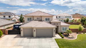 View of front facade with stucco siding, driveway, a garage, and a residential view