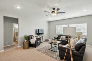 Living room with carpet floors, ceiling fan, recessed lighting, and a textured ceiling