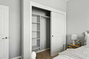Carpeted bedroom with a closet and baseboards