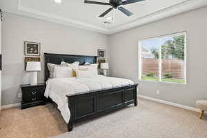 Bedroom featuring light colored carpet, a raised ceiling, recessed lighting, and a ceiling fan