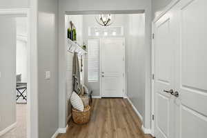 Foyer entrance featuring wood finished floors and a chandelier