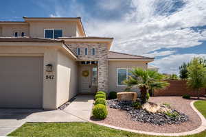 View of front of property with an attached garage, stucco siding, and a tiled roof