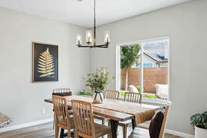 Dining space with wood finished floors and a chandelier