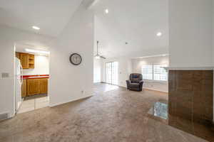 Living room with light colored carpet, high vaulted ceiling, recessed lighting, and a ceiling fan