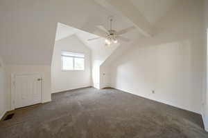 Additional living space with lofted ceiling, carpet floors, and a ceiling fan