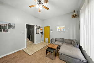 Living area with light colored carpet and a ceiling fan