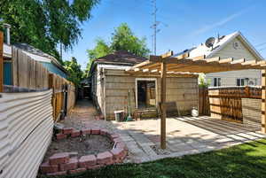 Rear view of house with a fenced backyard, a patio, and a pergola