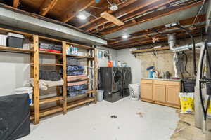 Unfinished below grade area with washing machine and dryer