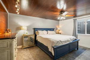 Bedroom featuring carpet, wooden ceiling, and a ceiling fan