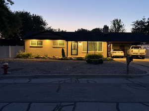 Single story home with concrete driveway, a chimney, an attached carport, and brick siding