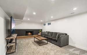 Living area featuring recessed lighting, a brick fireplace, and carpet floors