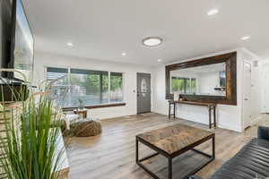 Living room with light wood finished floors and recessed lighting