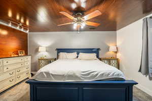 Bedroom with carpet flooring, wood ceiling, and a ceiling fan