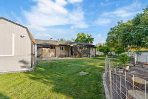 Fenced backyard with a vegetable garden and a patio