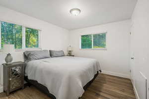Bedroom with wood finished floors and baseboards