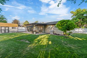 Rear view of house with a patio area, an outbuilding, french doors, and brick siding