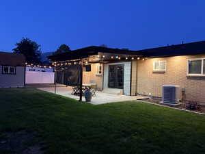 Back of house featuring a patio area, brick siding, and a storage shed
