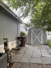 View of patio featuring a storage shed