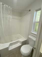 Bathroom featuring shower / bath combo and tile patterned flooring