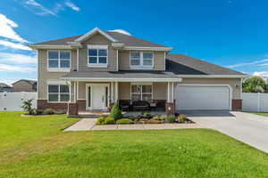View of front of home with brick siding, covered porch, an attached garage, concrete driveway, and roof with shingles