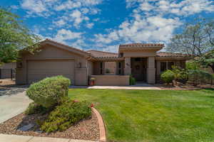 Mediterranean / spanish house with a tile roof, stucco siding, an attached garage, and concrete driveway