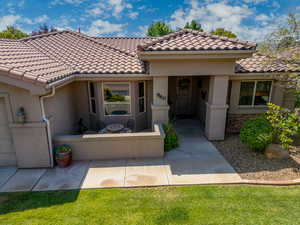 View of front facade with stucco siding and a tile roof