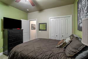 Carpeted bedroom with a closet and ceiling fan