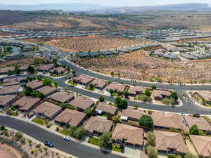 Aerial overview of property's location with a mountainous background and nearby suburban area