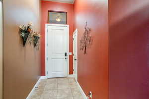 Doorway to outside with baseboards and light tile patterned floors