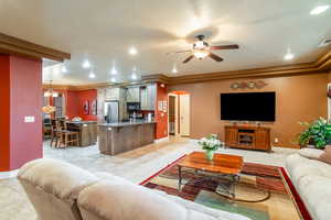 Living area with arched walkways, ceiling fan, light tile patterned flooring, recessed lighting, and a chandelier