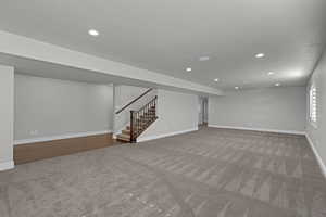 Basement with carpet, recessed lighting, and stairs