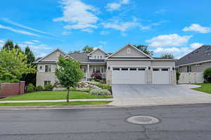 Traditional-style home with a garage, a gate, driveway, stucco siding, and stone siding