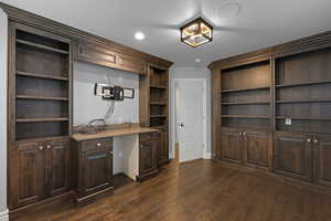 Unfurnished office featuring dark wood-style floors, built in study area, and recessed lighting
