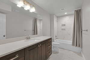 Full bath featuring marble look tile flooring, vanity, shower / bath combo with shower curtain, and recessed lighting